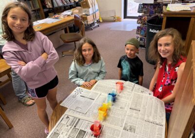 SRP Patrons rainbow experiement around table with paper towels, food coloring and water